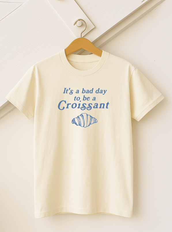 Adult Croissant T-shirt by The Wishing Elephant featuring a detailed croissant graphic on a casual tee shirt.