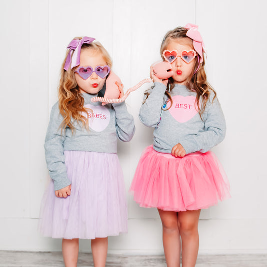 Matching heart sweatshirt for kids by The Wishing Elephant featuring a best friends design, pink fabric with heart motifs.